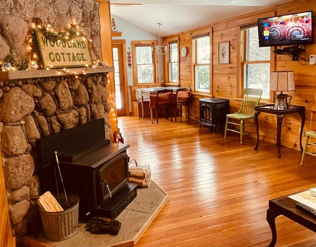 Living room with a stone fireplace and a wood stove.