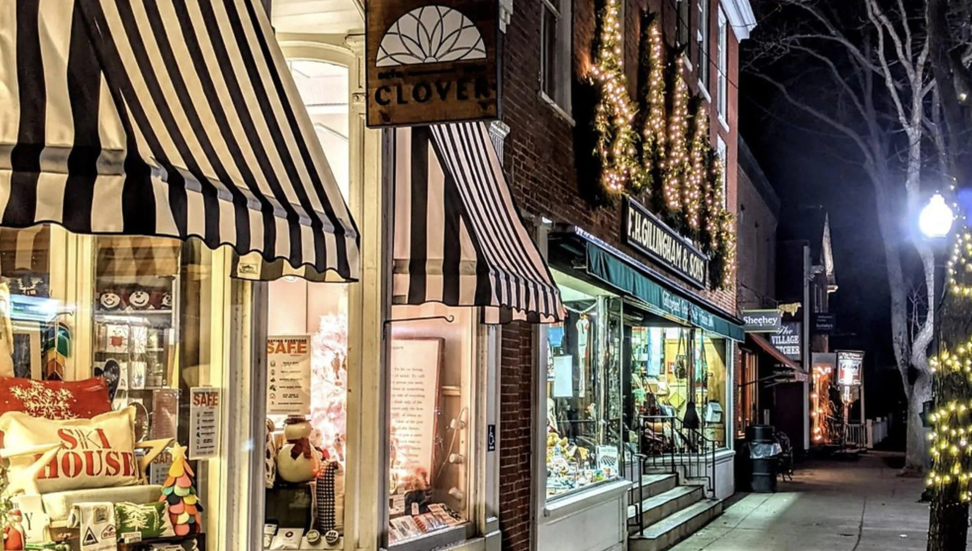 Shopfronts on a Woodstock street at night, awnings and string lights.